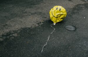 Deflated smiley face balloon.